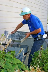 HVAC technician working on AC outdoor unit