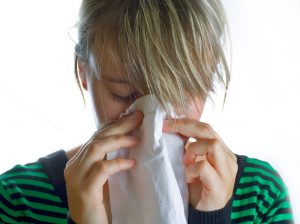 close-up-with-white-background-of-woman-blowing-her-nose