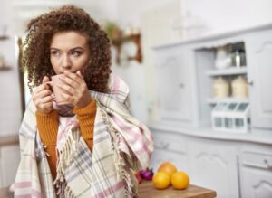 woman-wrapped-in-blanket-drinks-hot-beverage
