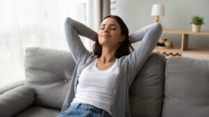 woman-leans-back-in-comfort-on-couch