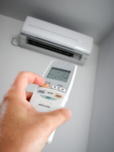 hand-holding-remote-pointed-at-ductless-air-handler