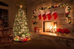 Christmas-tree-by-fireplace-with-stockings-and-garnland-hanging.