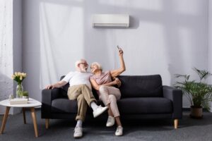 senior-couple-on-sofa-changing-temperature-of-mini-split-with-remote