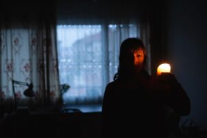 woman-holding-flashlight-in-dark-house